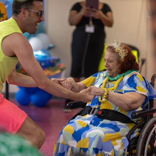 A man holding hands with a woman in a wheelchair