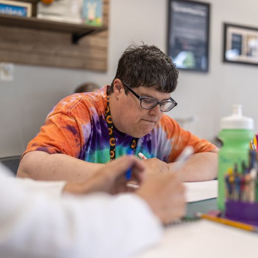 A person looking down and concentrated on what they're drawing