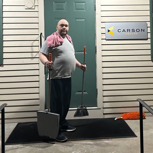 A man holding a broom and dust pan