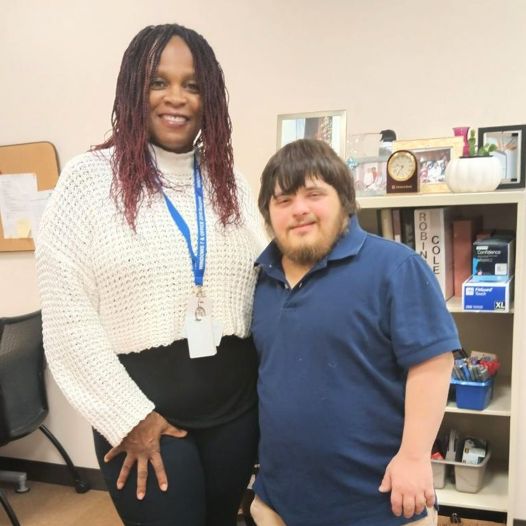 A man and woman side hugging, smiling towards the camera