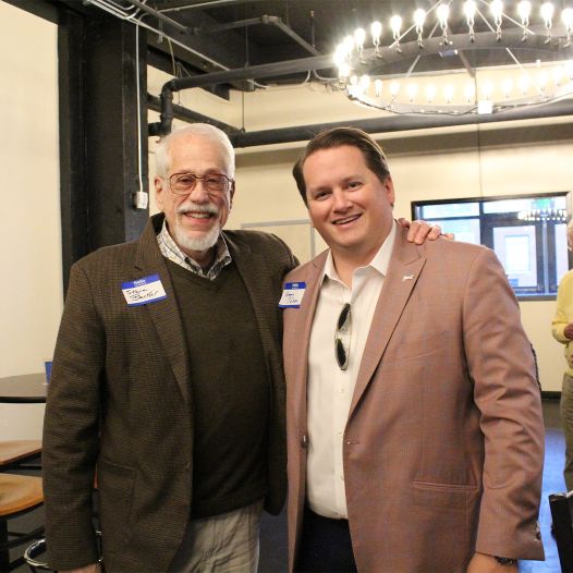 Two men with name tags and suits