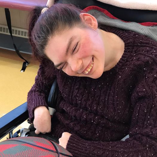 A woman in a wheelchair holding a basketball