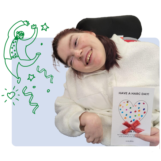 A woman in a wheelchair holding up a card 