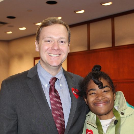 A man in a suit and younger woman taking a photo together