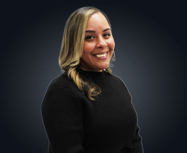 A headshot of a woman with long brown and blond hair